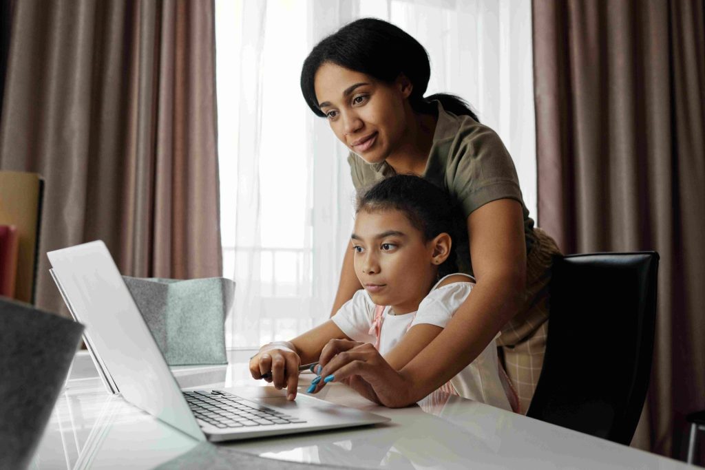 Une mère aide sa fille avec son ordinateur portable