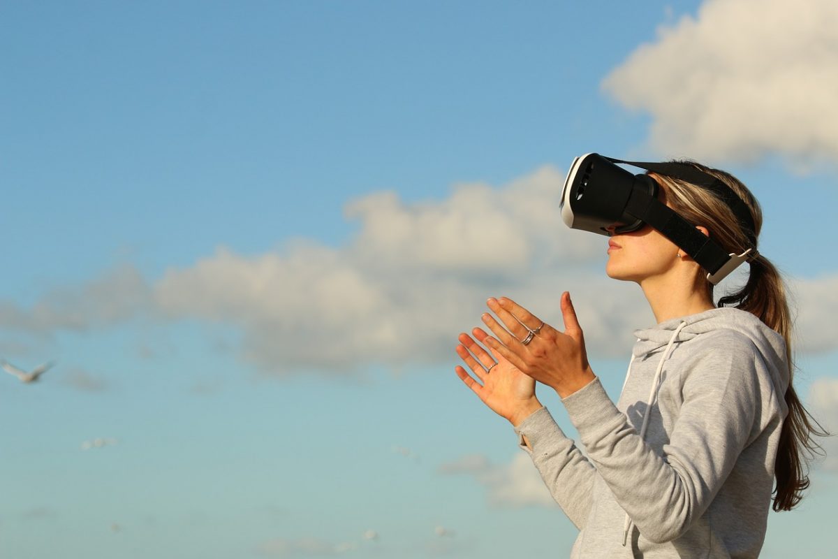 A woman using virtual reality VR googles and looking up to the sky