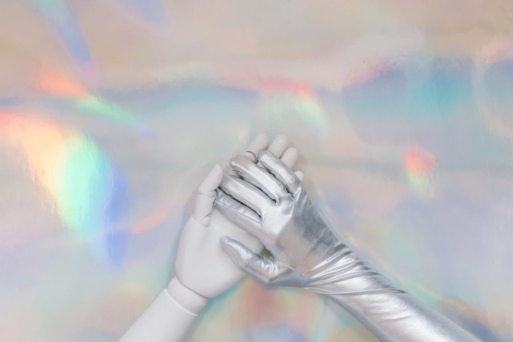 human hand resting on gloved AI robot hand