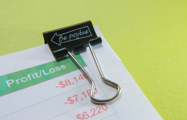 A paper clip with the words be positive on it
