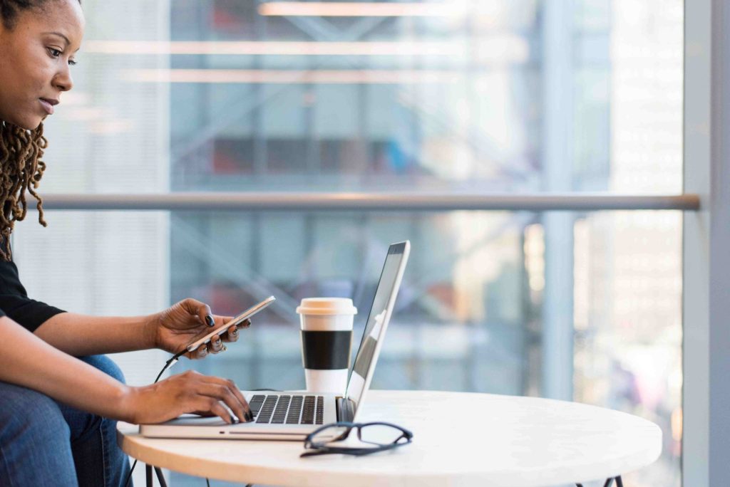 woman working on laptop and phone